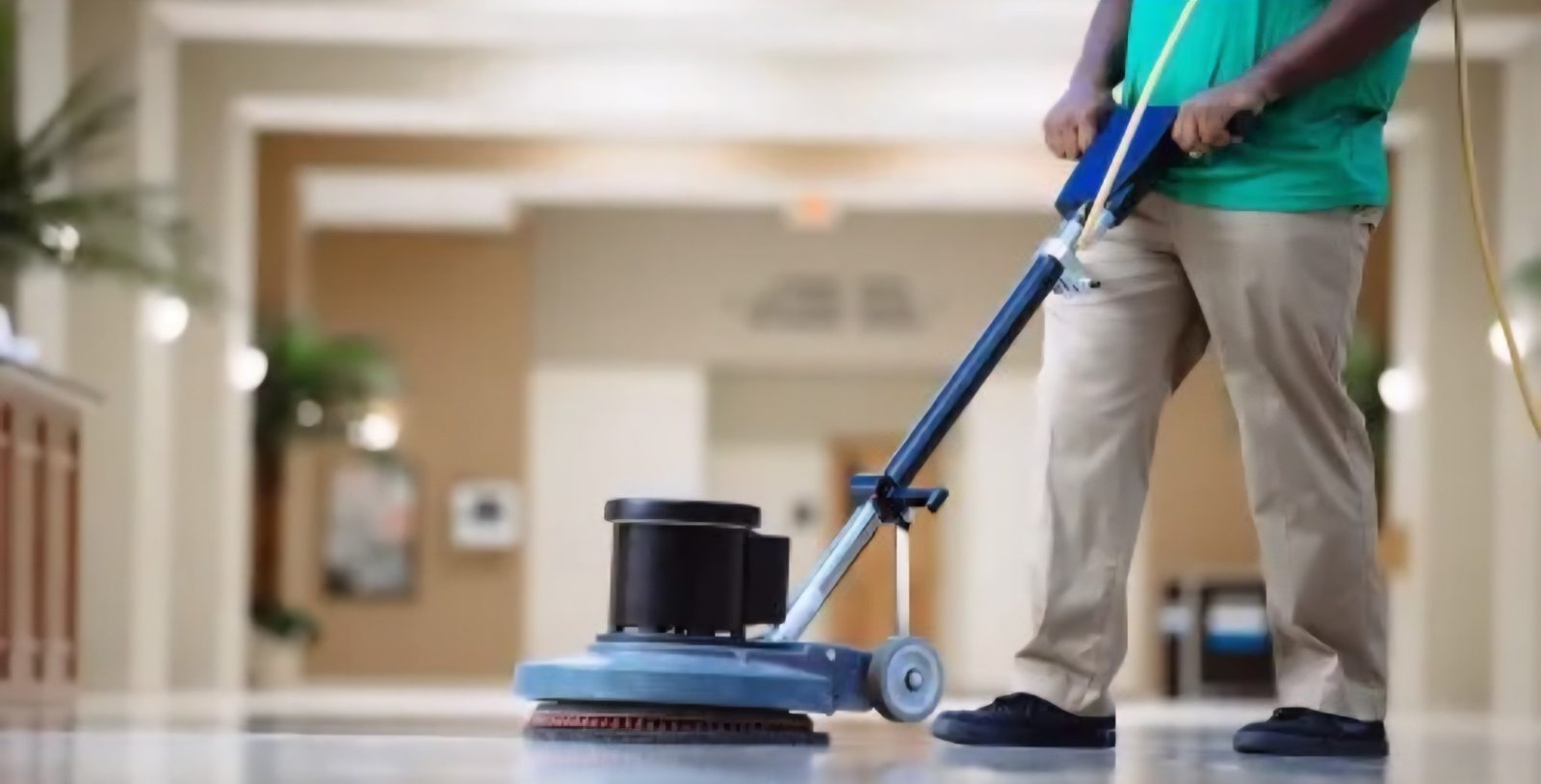 Worker operating a rotary floor polishing machine